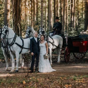 Bruidspaar bij trouwvervoer koets met paarden