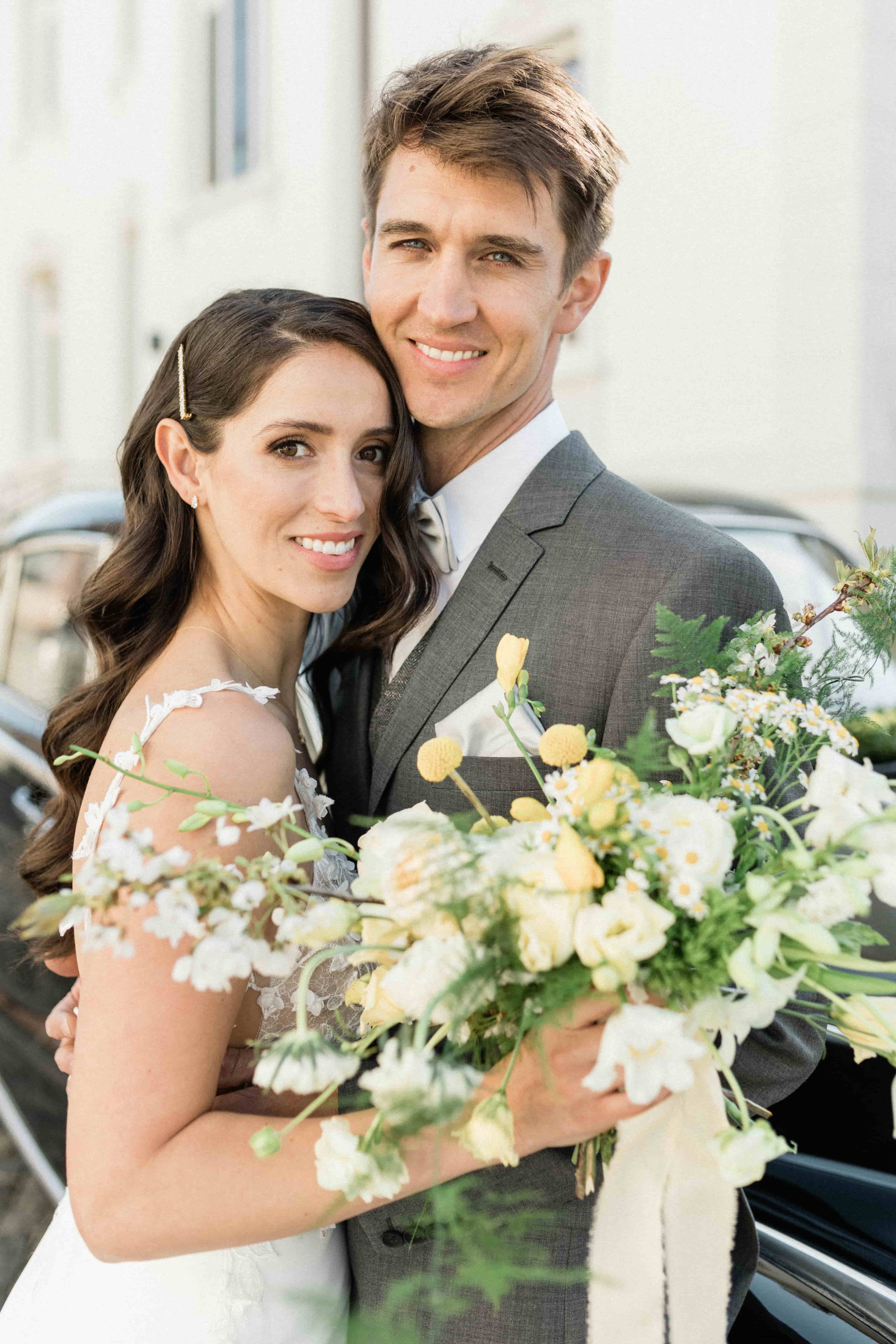 Vrolijk bruidspaar, Bruid heeft bruidsboeket met gele bloemen.
