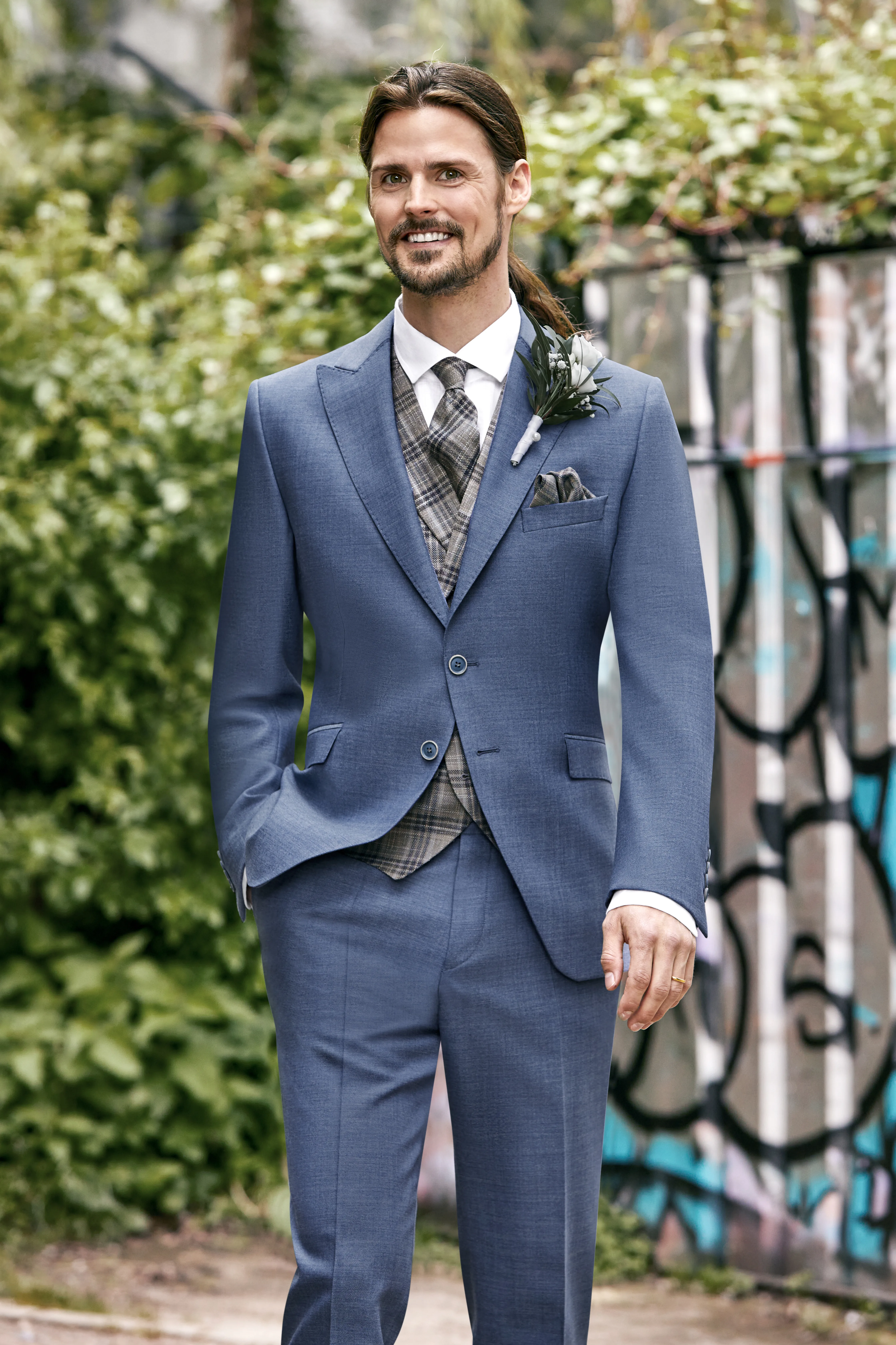 Man in blauw trouwpak met stropdas met print.