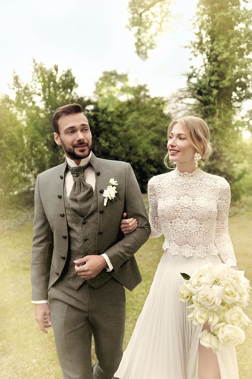 Bruidspaar loopt door groene tuin.