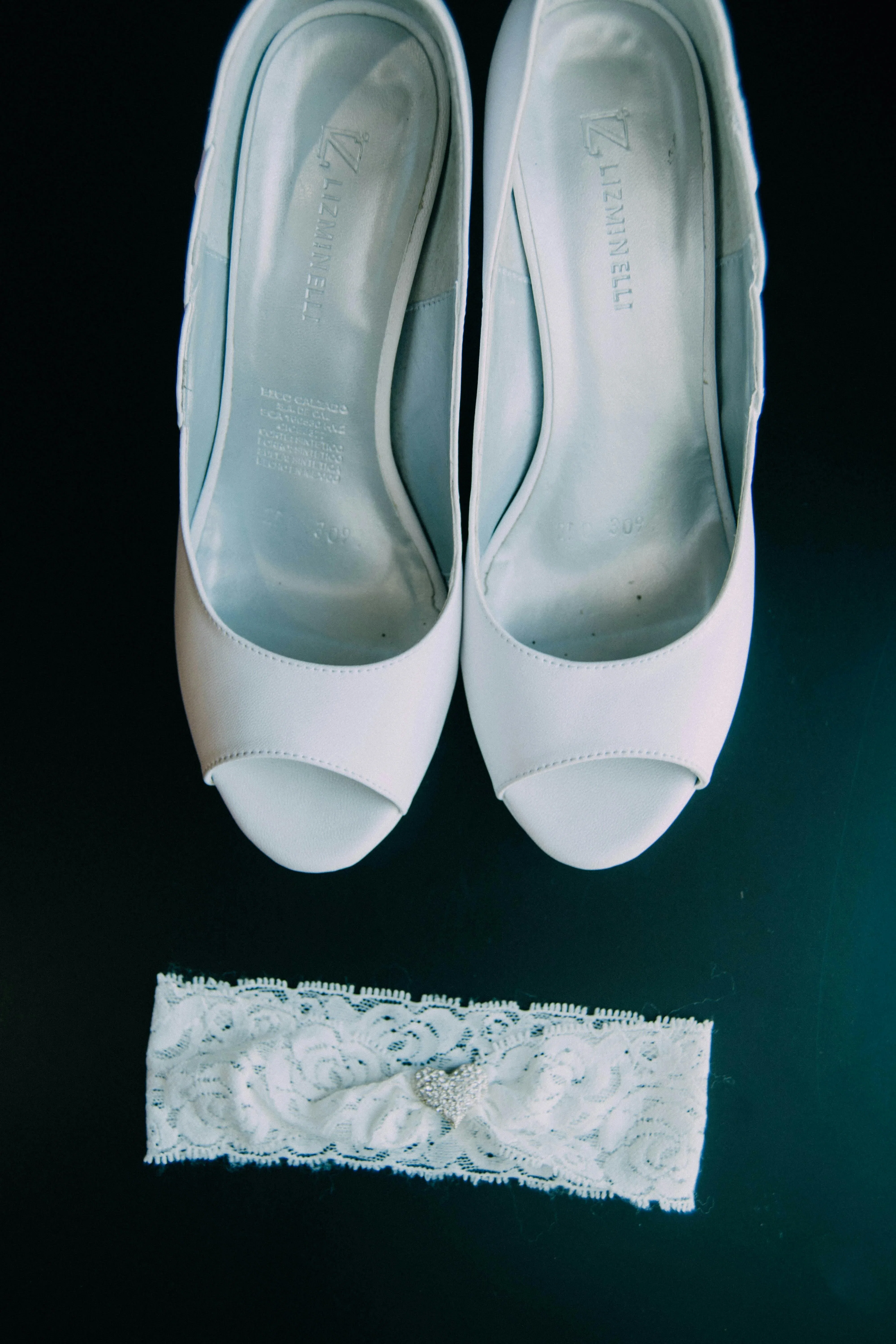 Witte kousenband en witte trouwschoenen