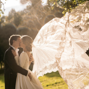 Bruidspaar dat kust, sluier waait in de wind.