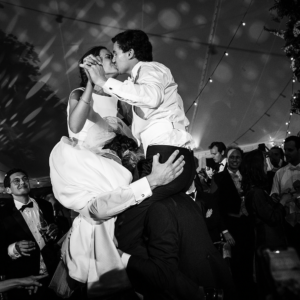 Bruidspaar tijdens het feest, beiden op de schouders van vrienden of familie.