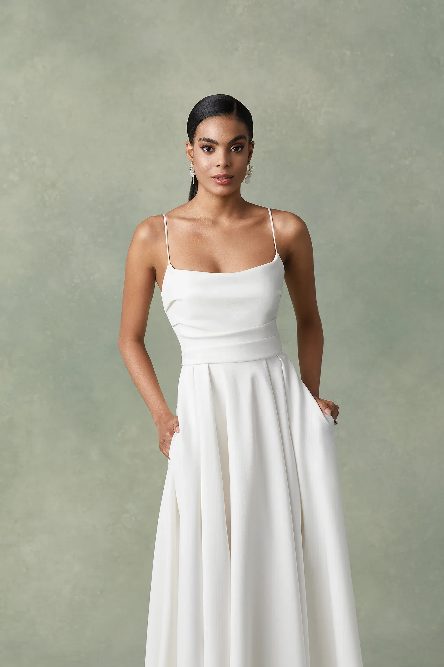 Bruid in minimalistische trouwjurk met split en spaghettibandjes.