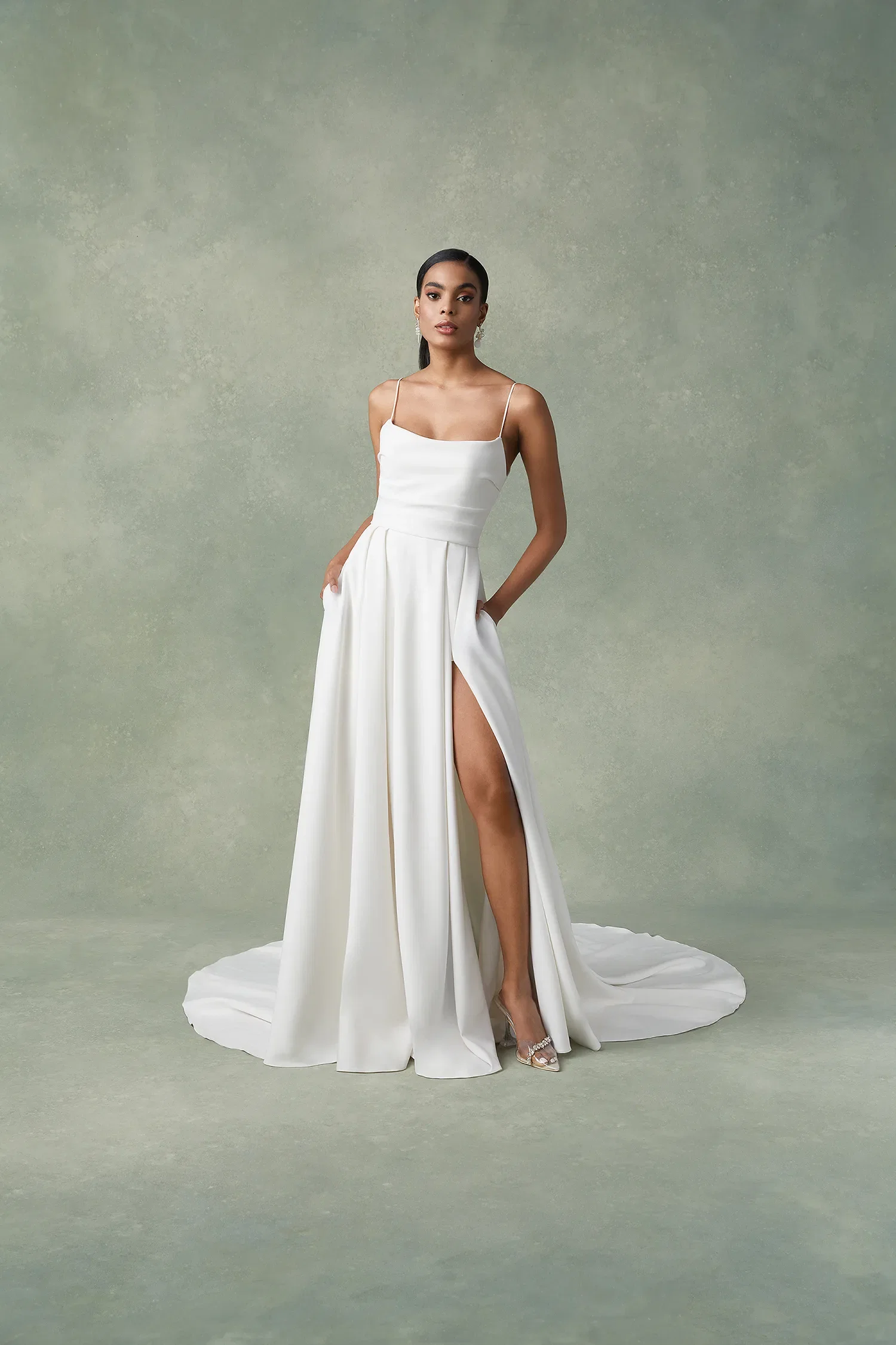 Bruid in minimalistische trouwjurk met split en spaghettibandjes.