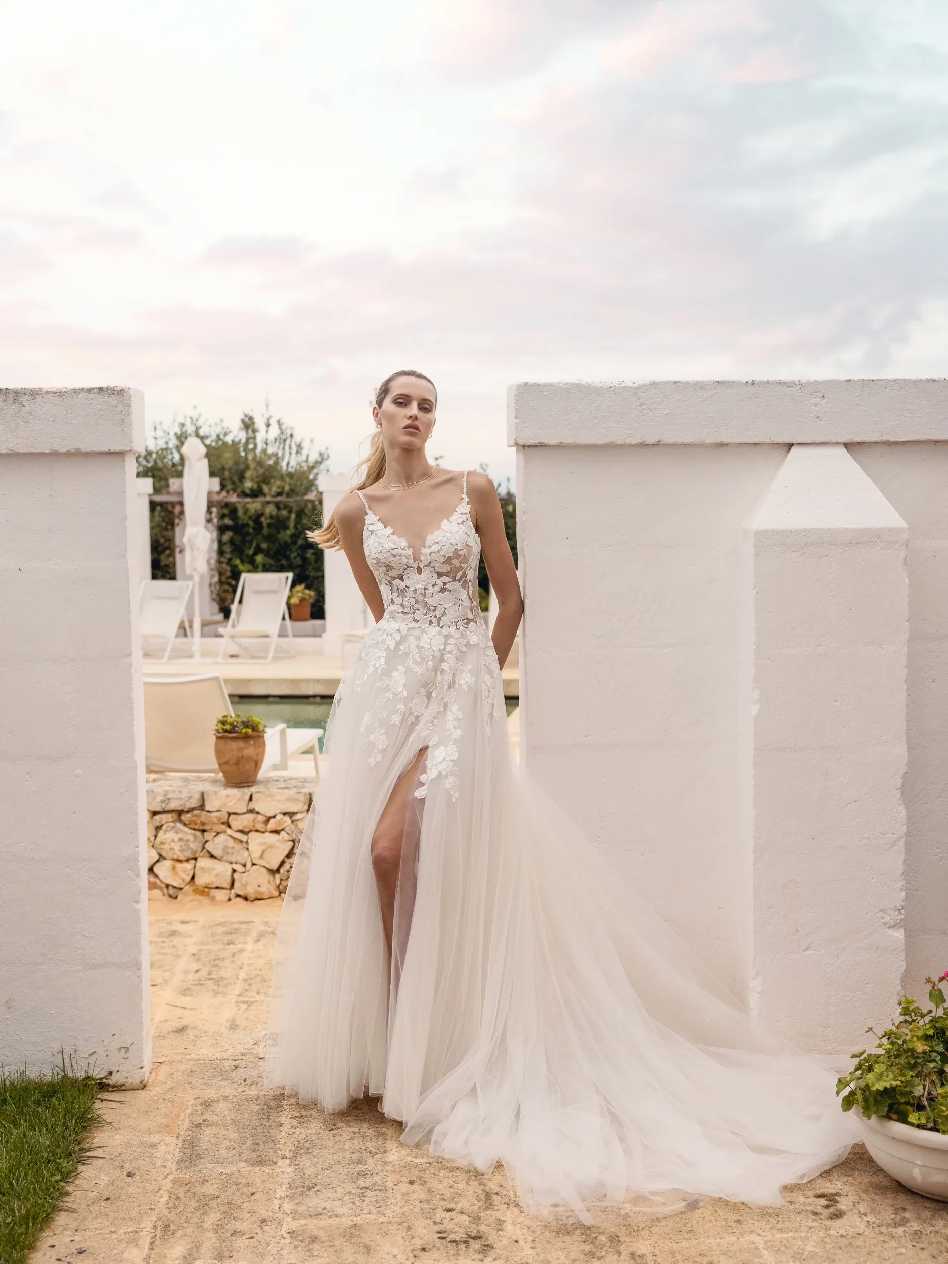 Bruid in crème witte trouwjurk met applicaties, tule en een split.