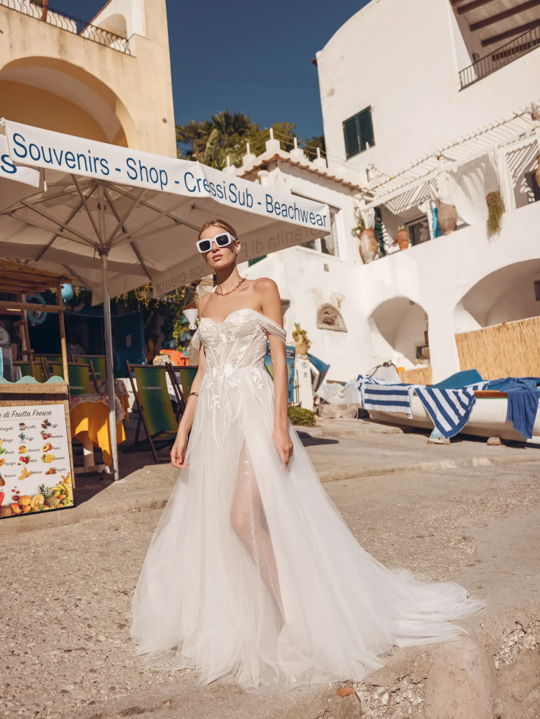 Bruid in prachtige off the shoulder trouwjurk met split en applicaties.