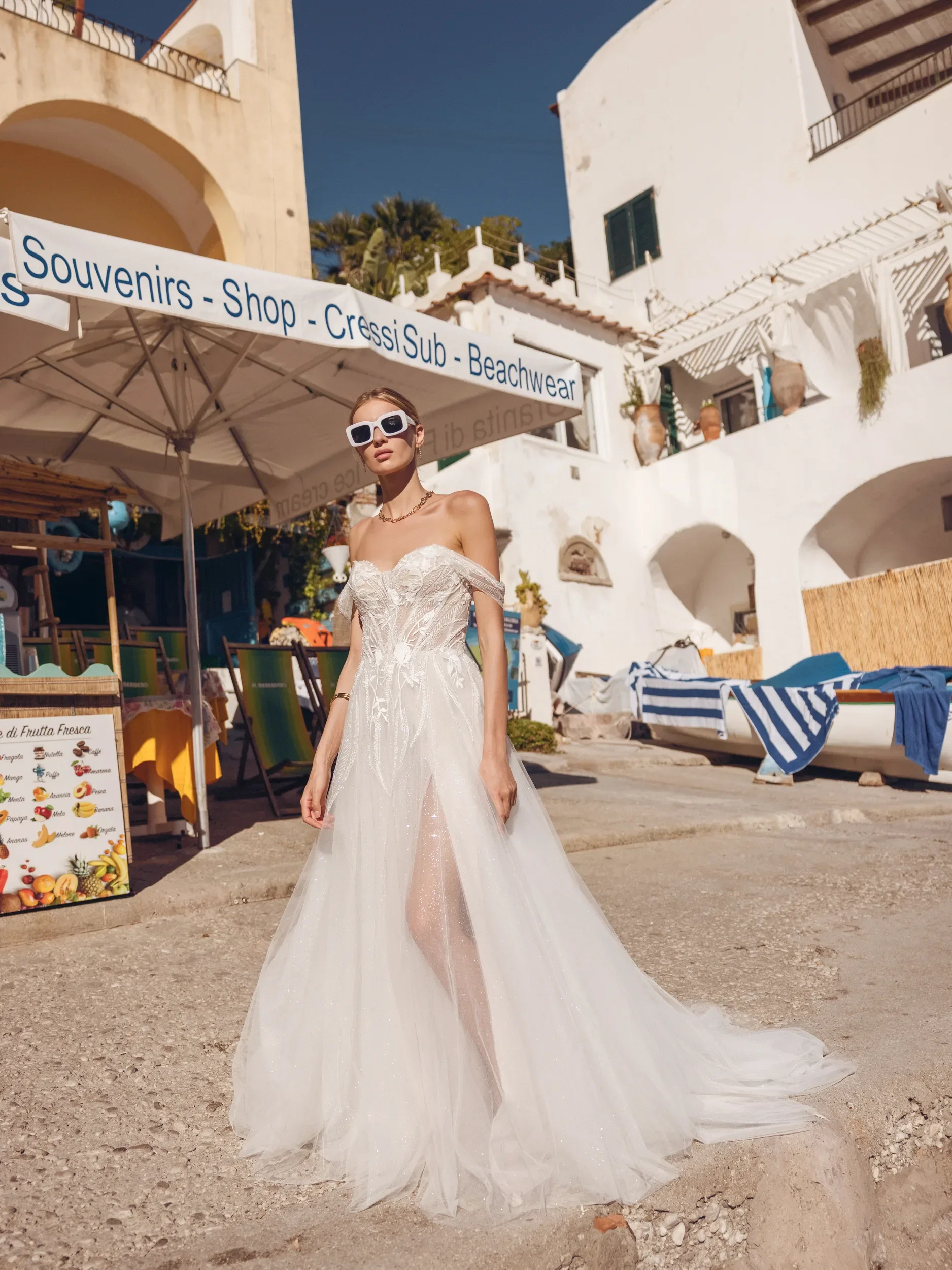 Bruid in prachtige off the shoulder trouwjurk met split en applicaties.