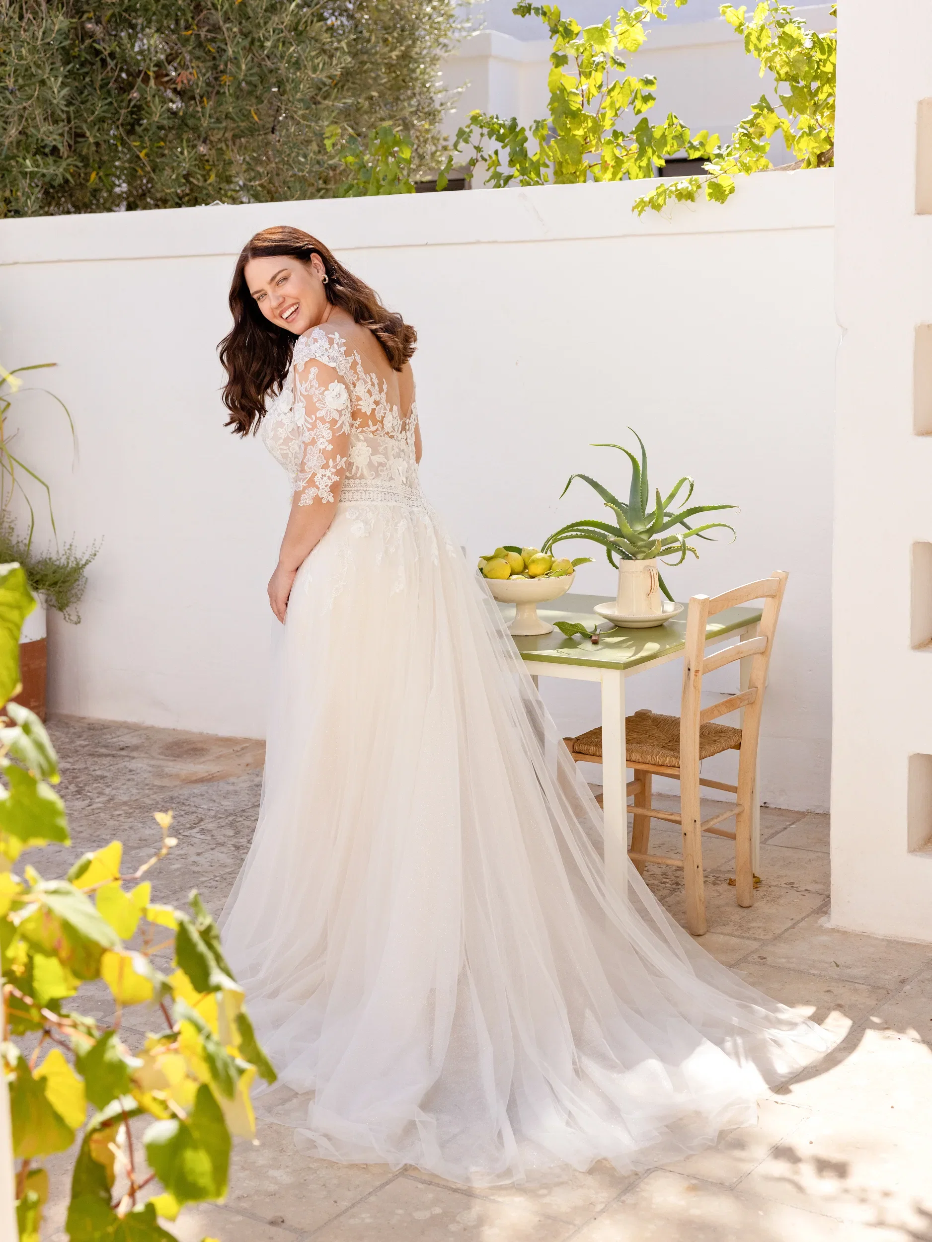 Vrolijke bruid in kanten bruidsjurk met tule.