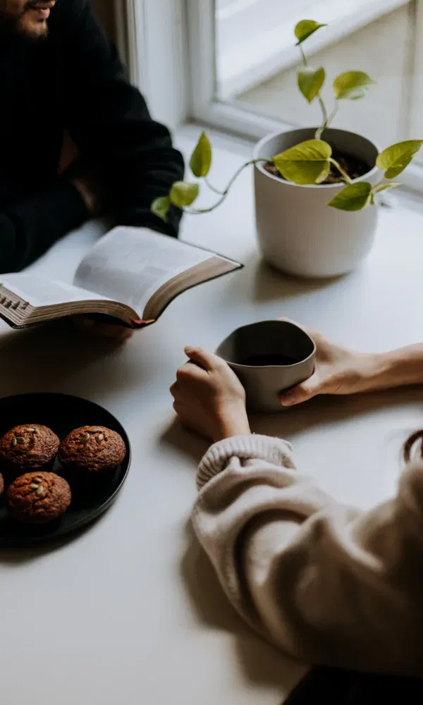 Koppel maakt samen planning aan tafel met koffie en koekjes.