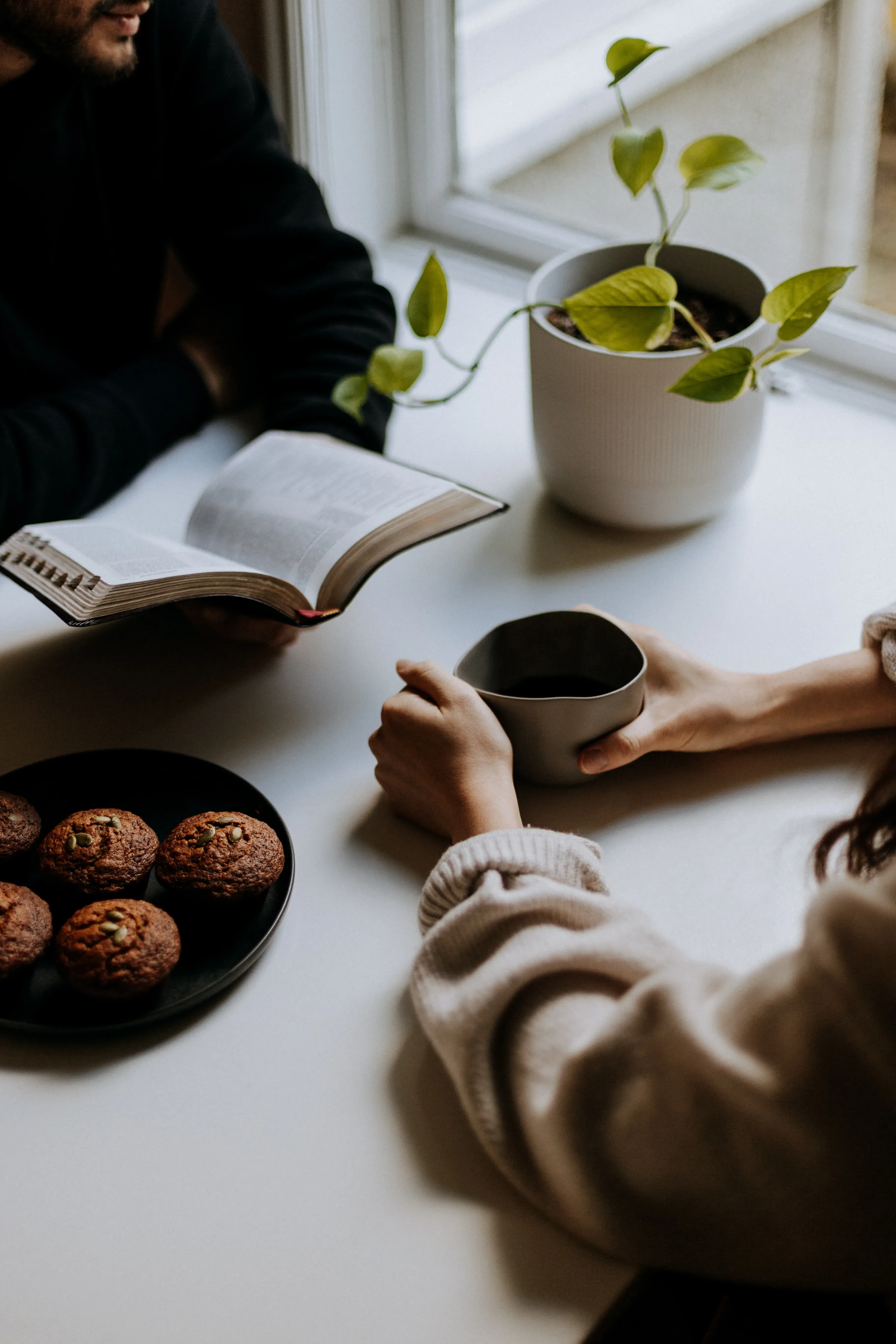 Koppel maakt samen planning aan tafel met koffie en koekjes.