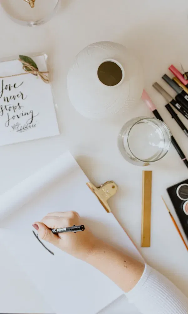 Vrouwenhand die handlettering tekening maakt met pen.