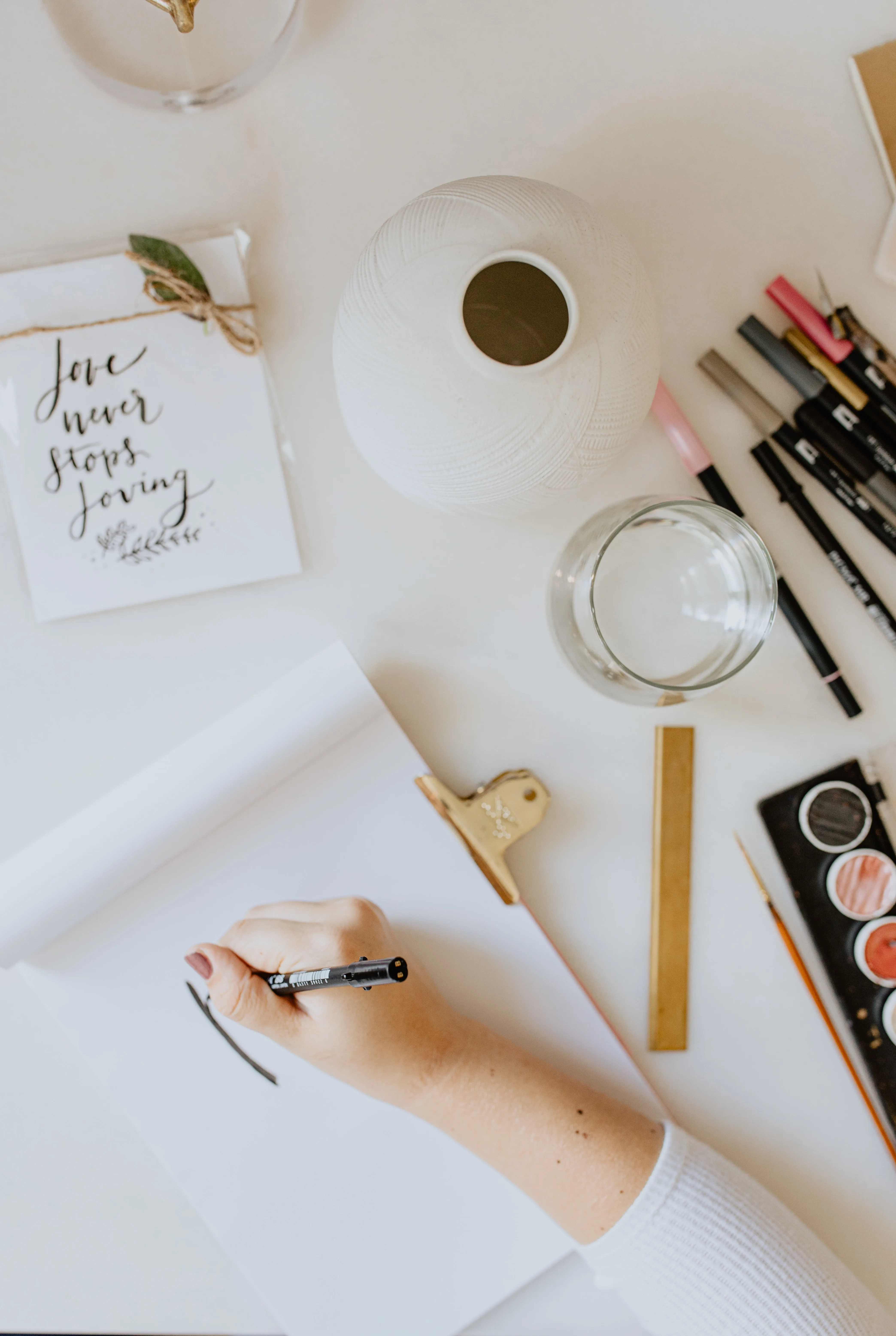 Vrouwenhand die handlettering tekening maakt met pen.