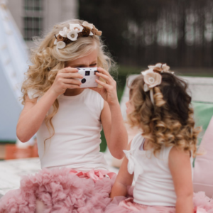 Kinderen op bruiloft. Twee kleine meisjes met fotocamera.