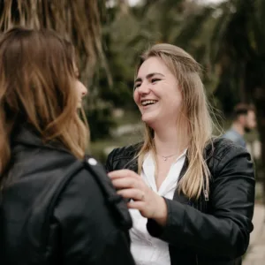 Twee lachende vrouwen bij een boom