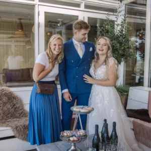 Drie lachende mensen op een bruiloft