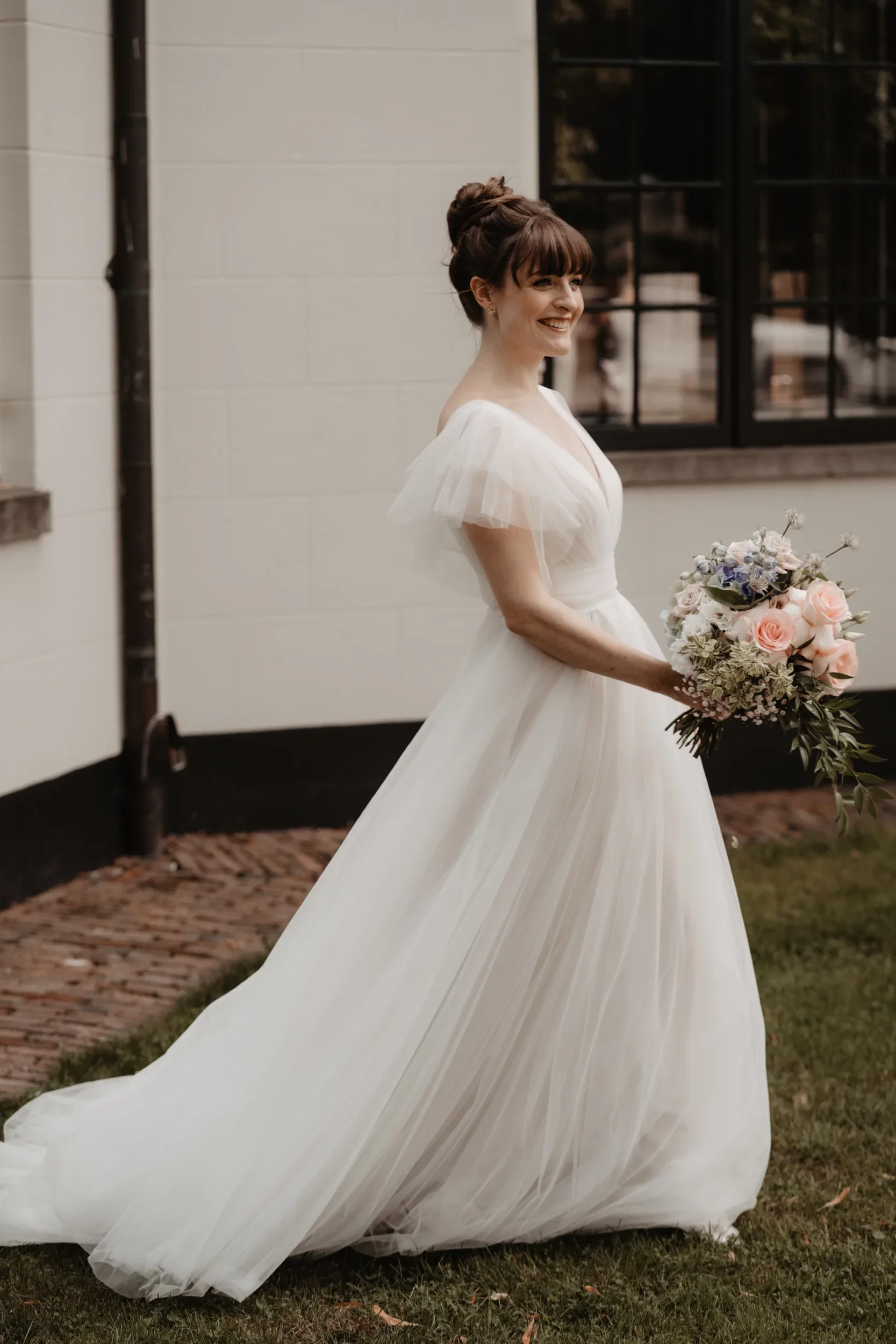 Lachende bruid met haar bloemen