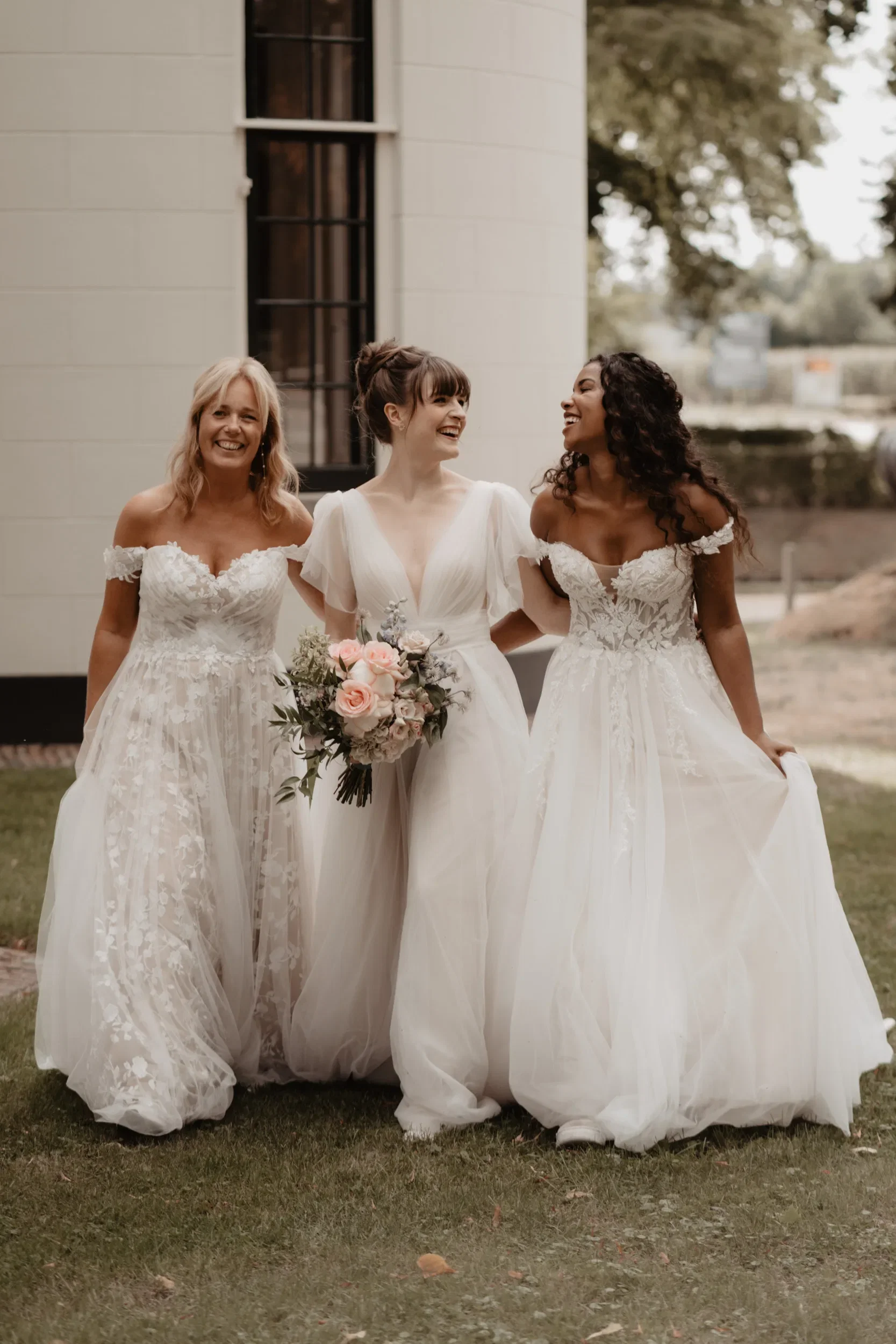 Drie bruiden die lachen naar elkaar