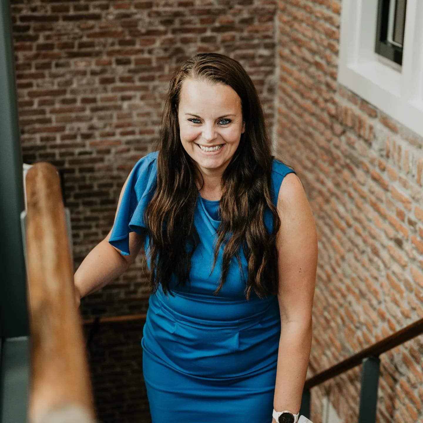 Lachende vrouw in blauwe jurk