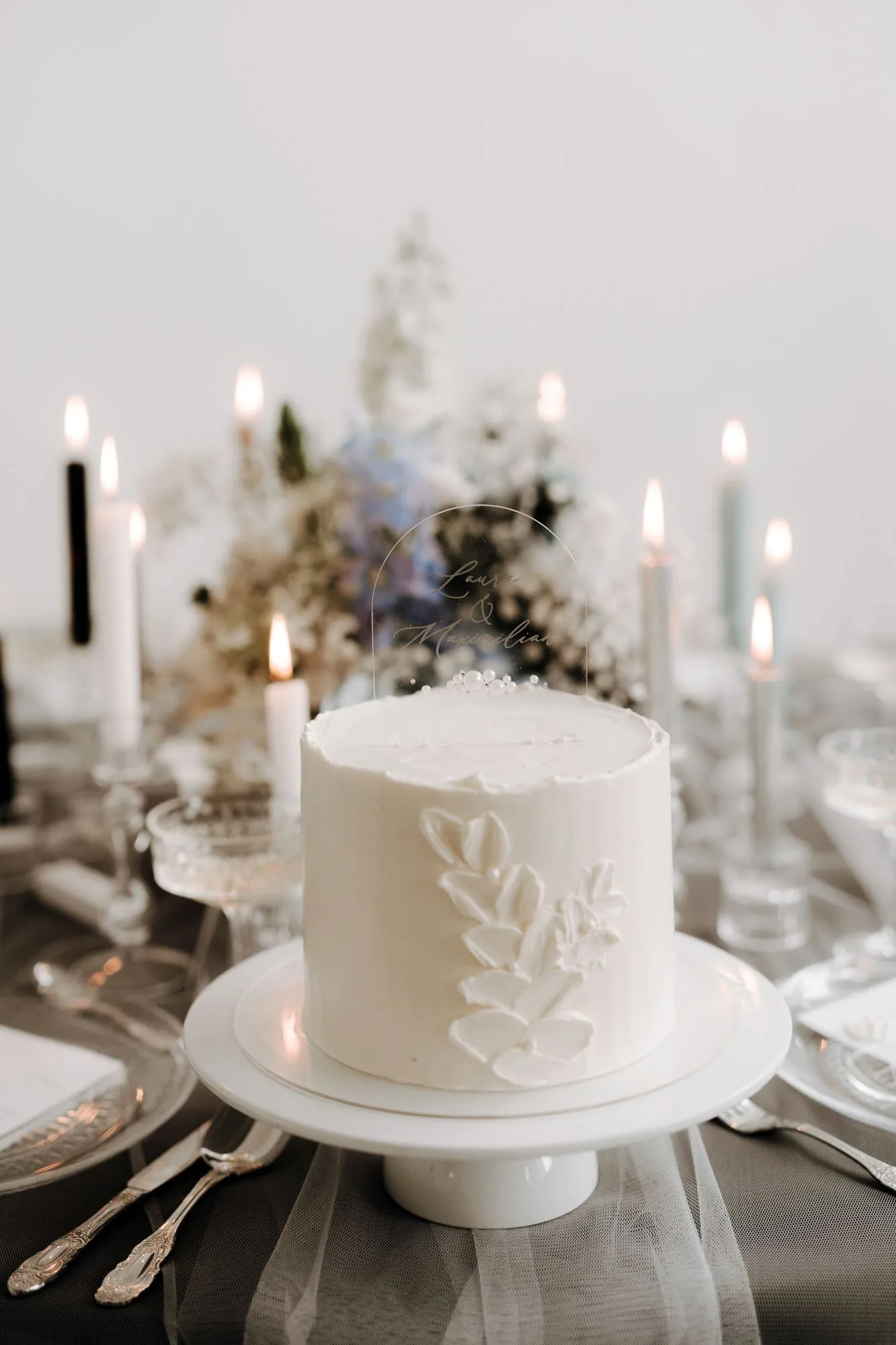 Een bruidstaart op een tafel met kaarsen