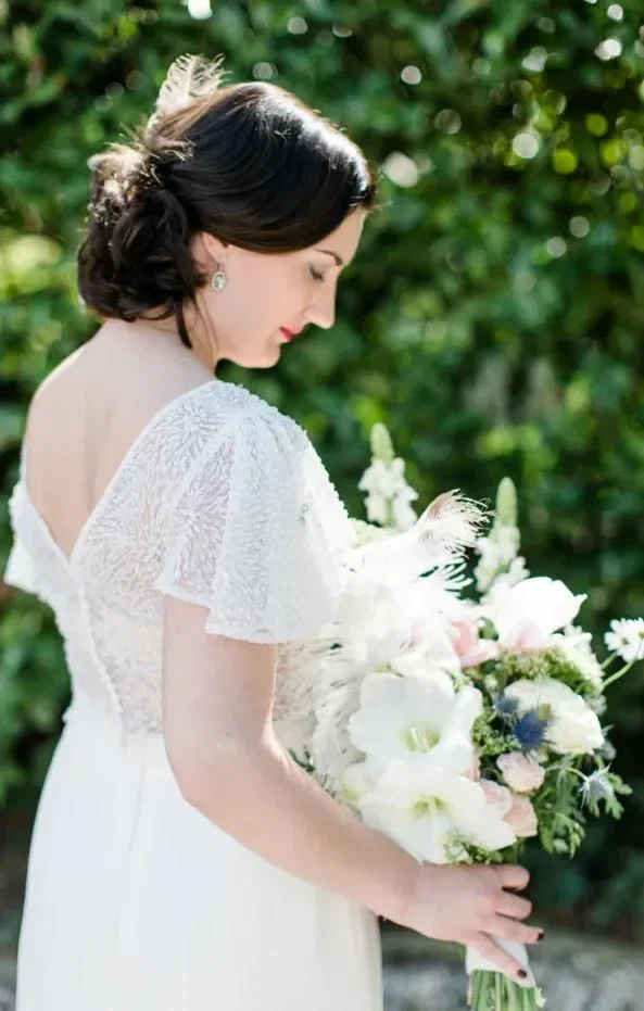 Bruid met witte bruidsjurk en een wit bruidsboeket