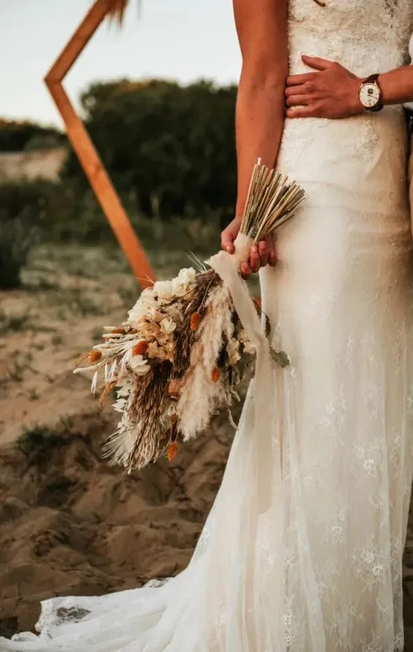 Bruidsbloemen met veren en een witte trouwjurk