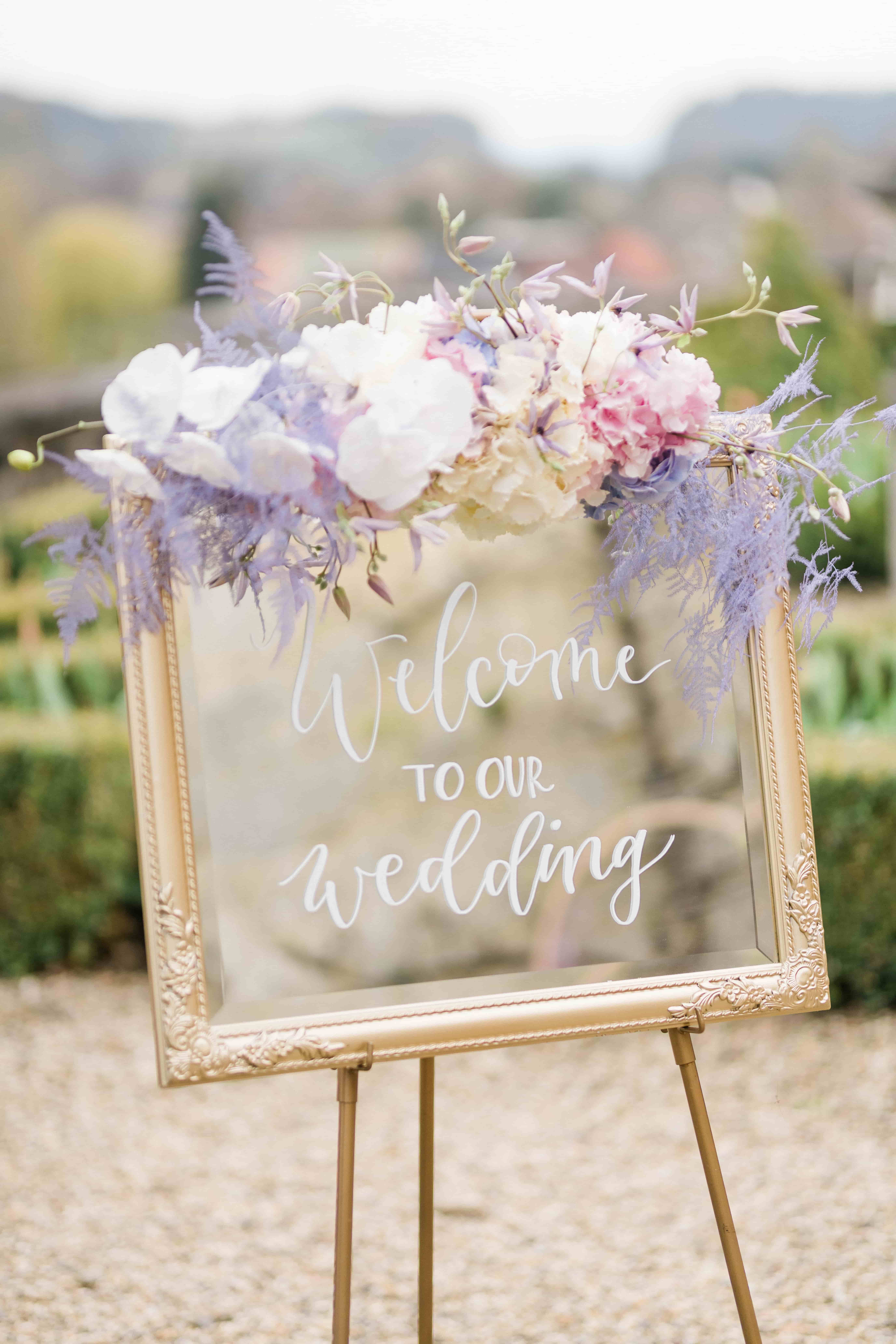Een bord met 'welcome to our wedding' op een bruiloft