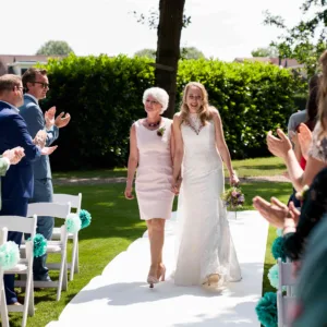 Een bruid die met haar moeder op de bruiloft loopt