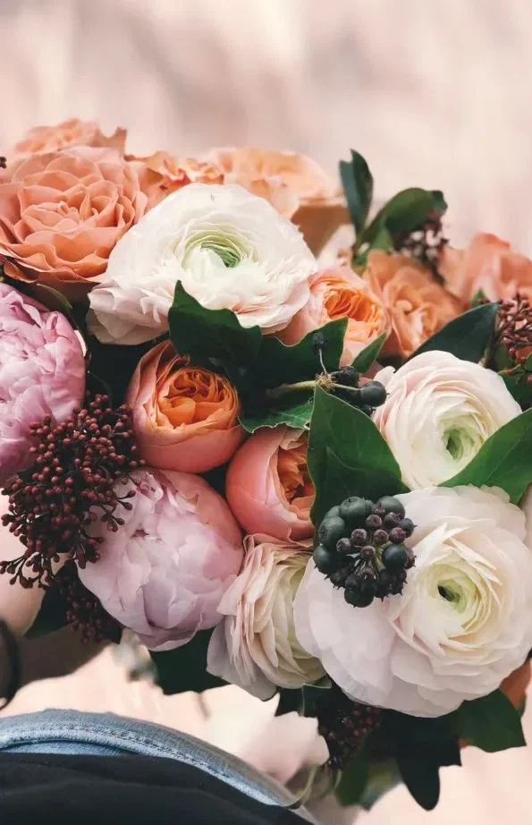 Een bruidsboeket van klaprozen in roze, wit en oranje