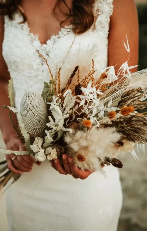 Bruidsbloemen met veren en een witte trouwjurk