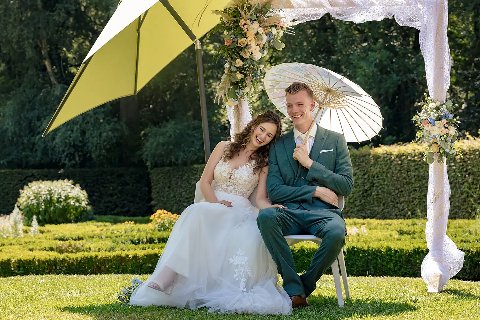 Bruidspaar tijdens ceremonie in warme zonnige tuin van Dudok in het Park.
