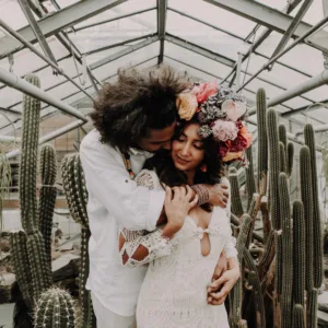 Bruidspaar in botanische tuin met cactus op de achtergrond.
