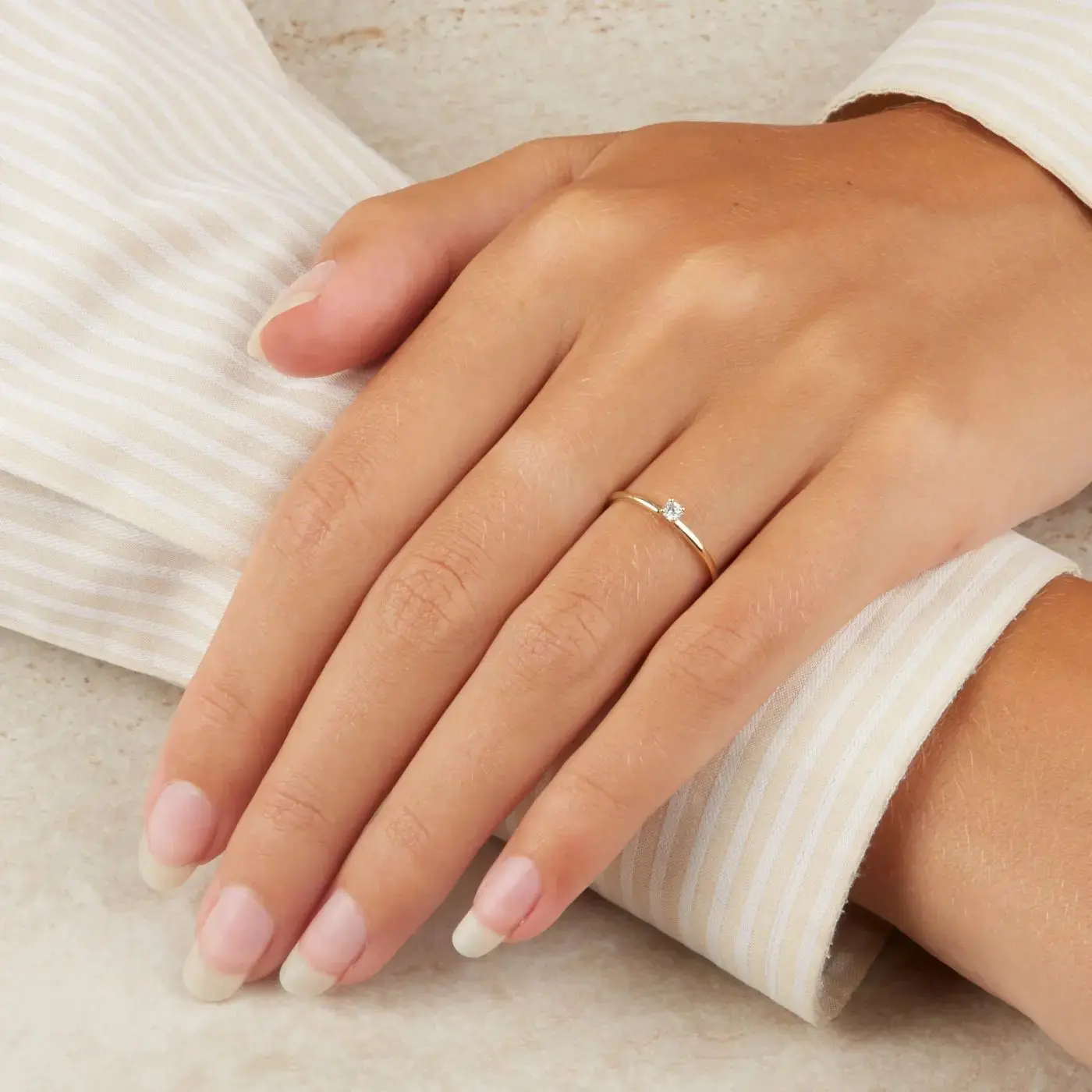 vrouwenhand met gouden ring met kleine diamant