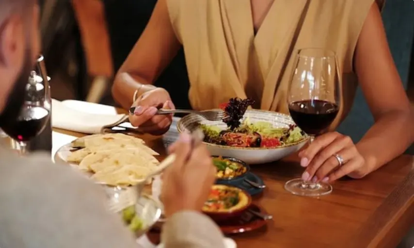 stel dat samen uit eten is en wijn drinkt.