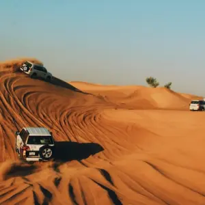 Auto's die rijden door de woestijn van Dubai