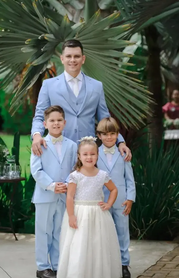 Foto van bruidegom met bruidsmeisje en bruidsjonkers in matching bruidskleding.