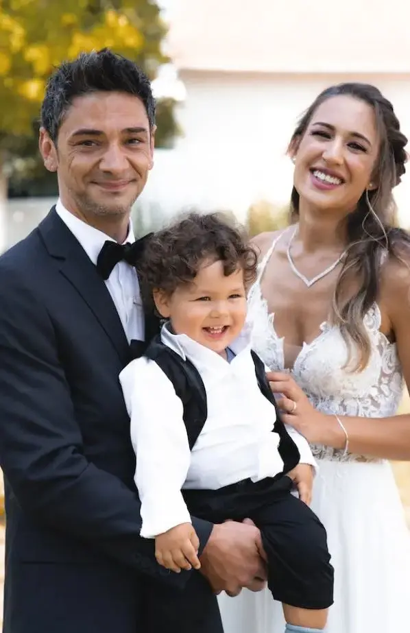 Gelukkig bruidspaar met bruidsjonker in matching outfit.