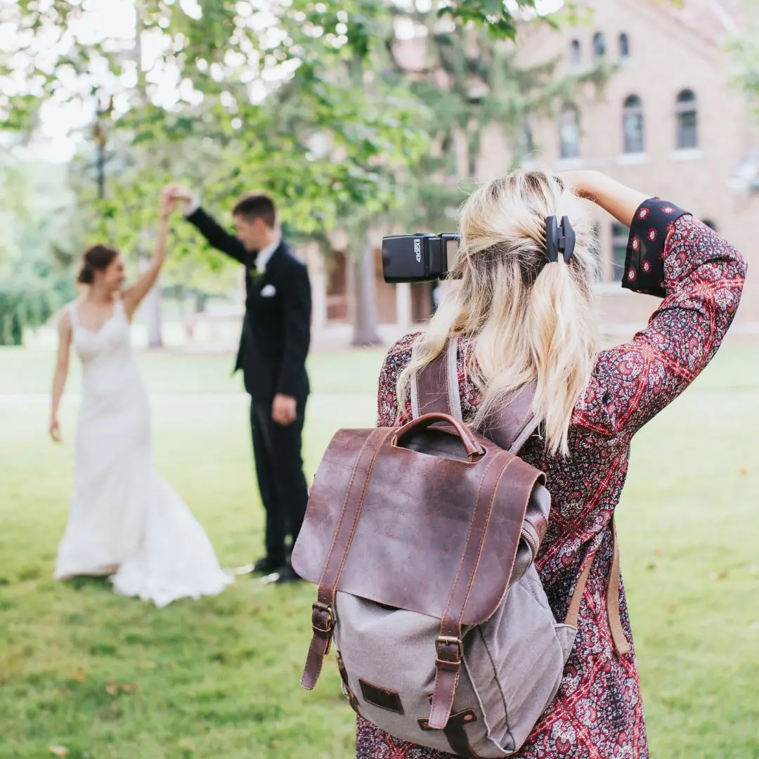 trouwfotograaf die buiten foto's maakt van een bruidspaar.