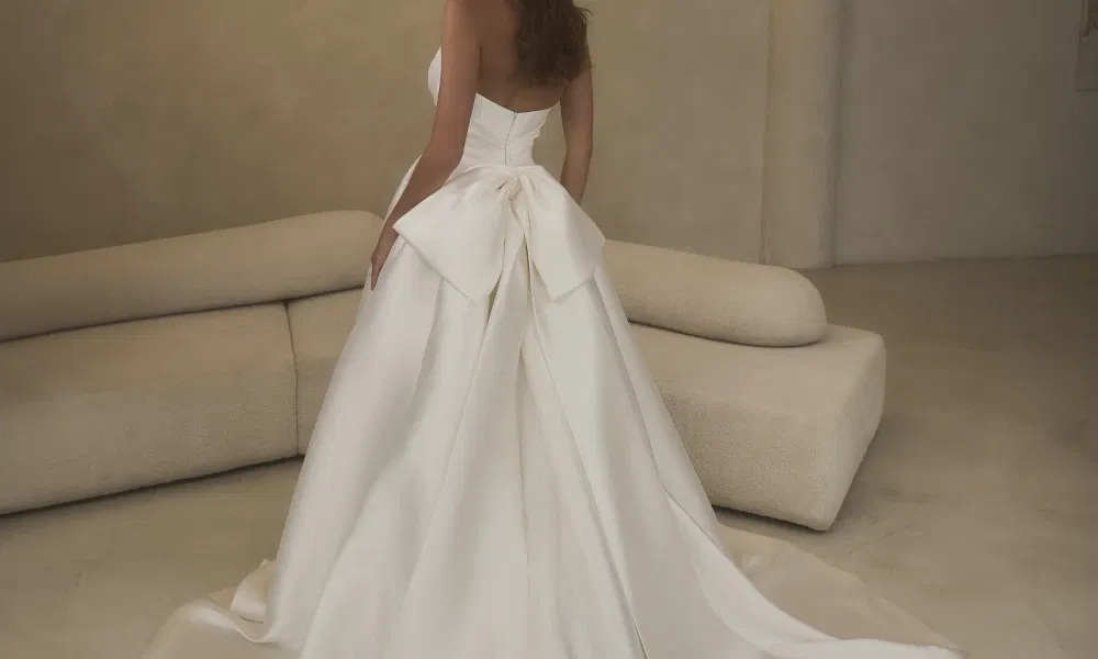 Ivoorkleurige trouwjurk van Casablanca met een grote strik achterop.