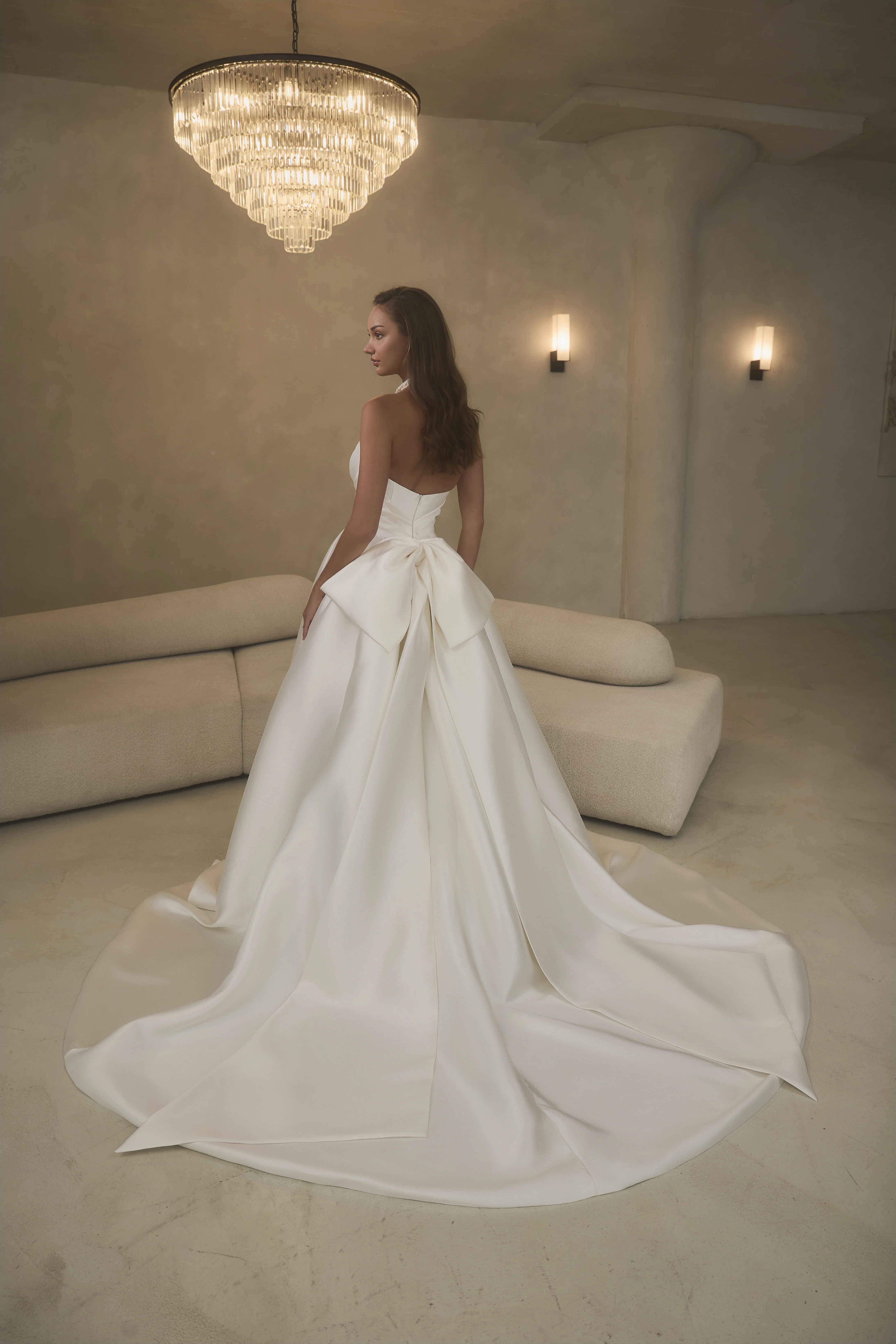 Ivoorkleurige trouwjurk van Casablanca met een grote strik achterop.