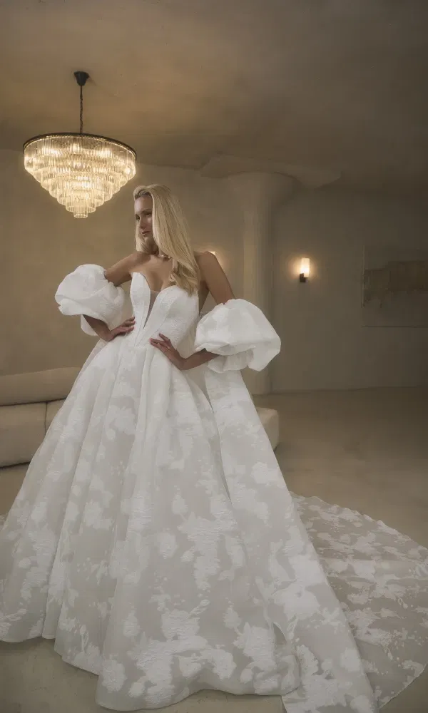 Trouwjurk vervaardigd in jacquard met bloemenreliëf, gelaagd over tule en voering, heeft het sculpturale strapless lijfje een diep uitgesneden sweetheart-halslijn en een flatterende basque taille.