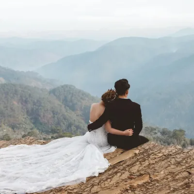 Buitenbruiloft in de bergen met avontuurlijk bruidspaar tijdens zonsondergang