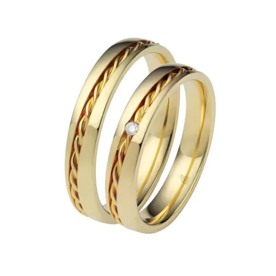 Elegante geelgouden trouwringen van Aller Spanninga – klassieke ringen met gevlochten roodgouden detail en diamant, tijdloos en romantisch design voor bruidsparen.