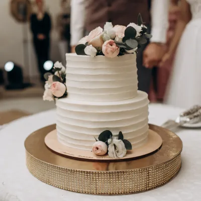 Klassieke witte bruidstaart met bloemendecoratie in romantische setting