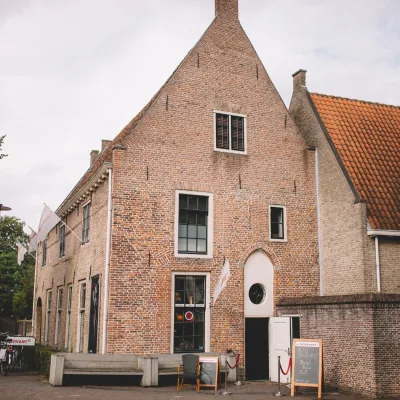 Ouderwets bakstenen pand met klassieke ramen en moderne horeca, geschikt voor unieke bruiloften