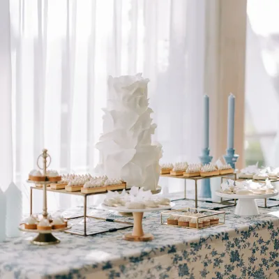 Sweettable voor een bruiloft met taart, cupcakes en bloemen in zachte tinten