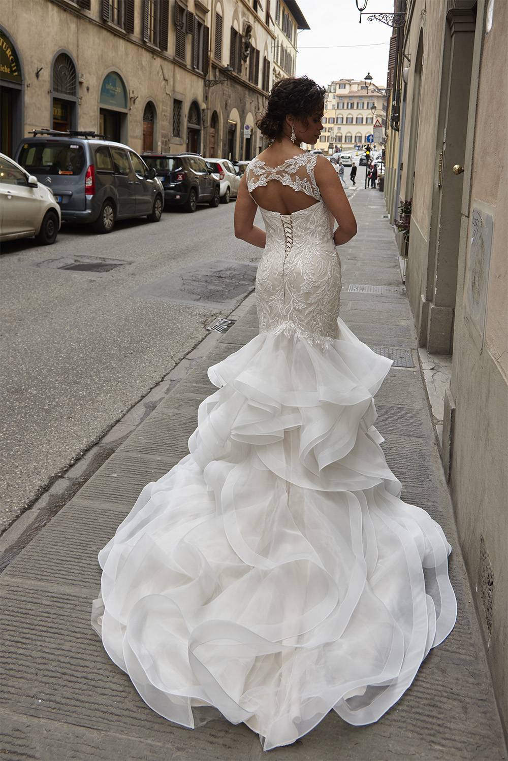 Bruid in Diane Legrand trouwjurk in mermaid fit and flare model met lange sleep van organza.
